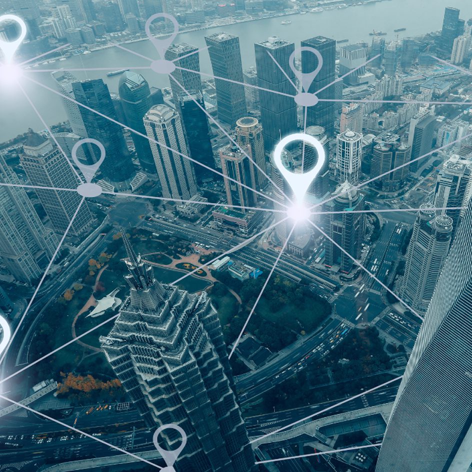 Aerial city view overlaid with digital geospatial location pins representing data-driven infrastructure solutions