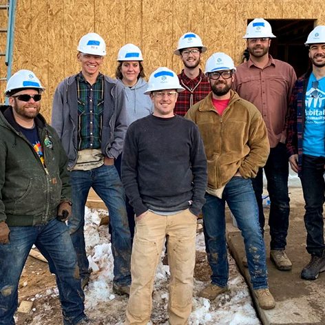 Group of volunteers wearing hard hats at a construction site